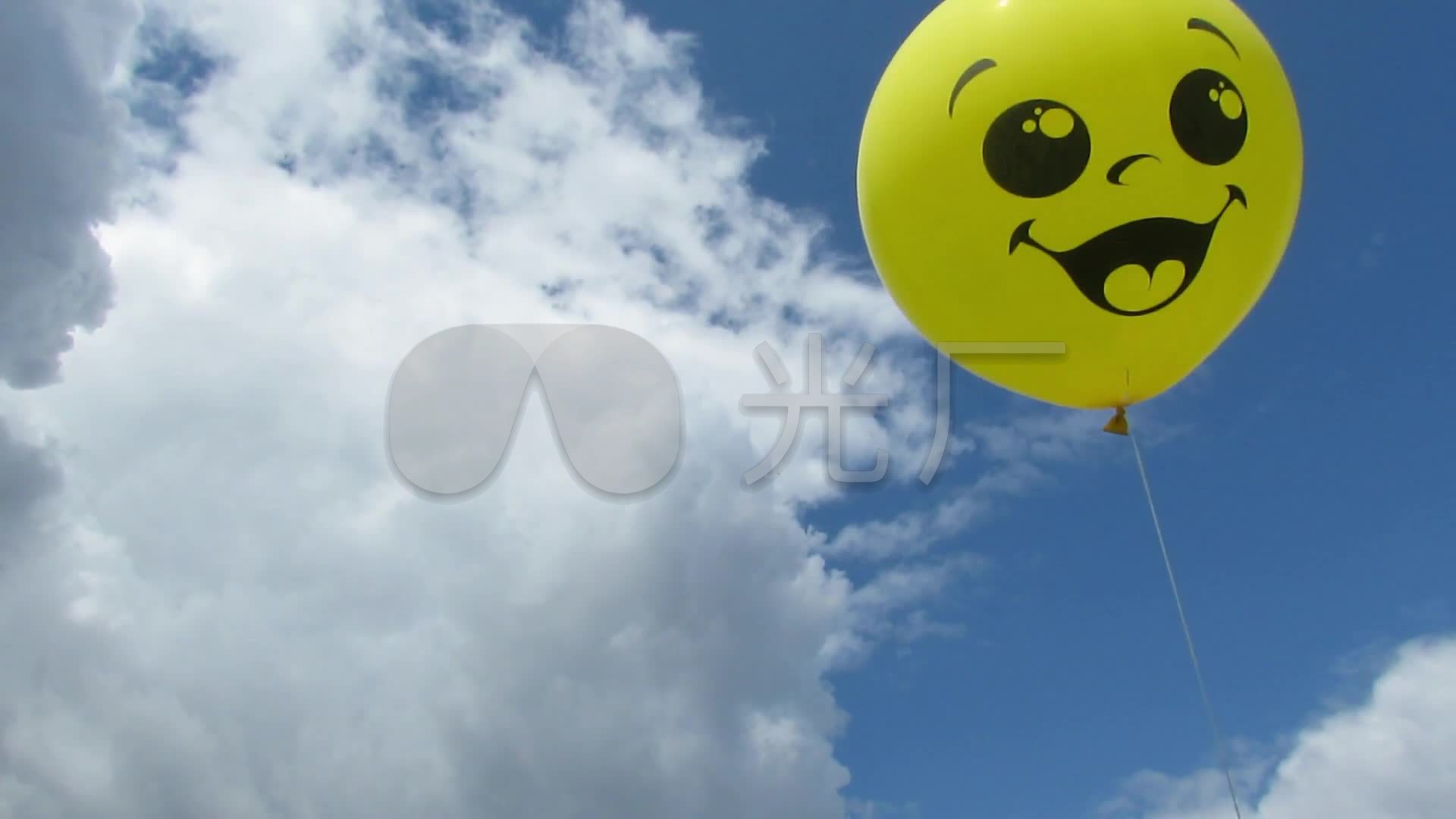蓝天白云下一只黄色的笑脸气球