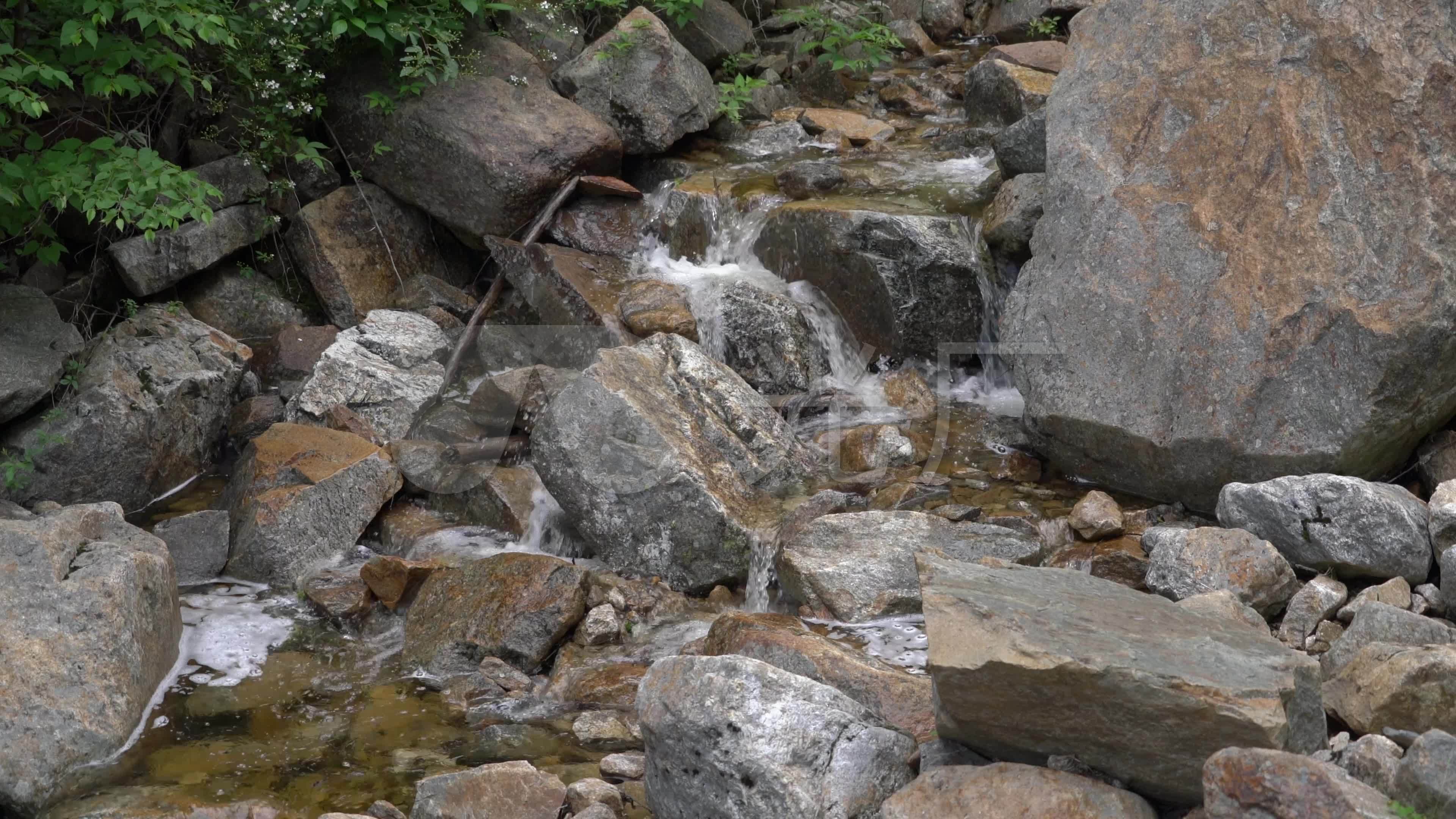 4k山涧岩石中流淌的溪水高清实