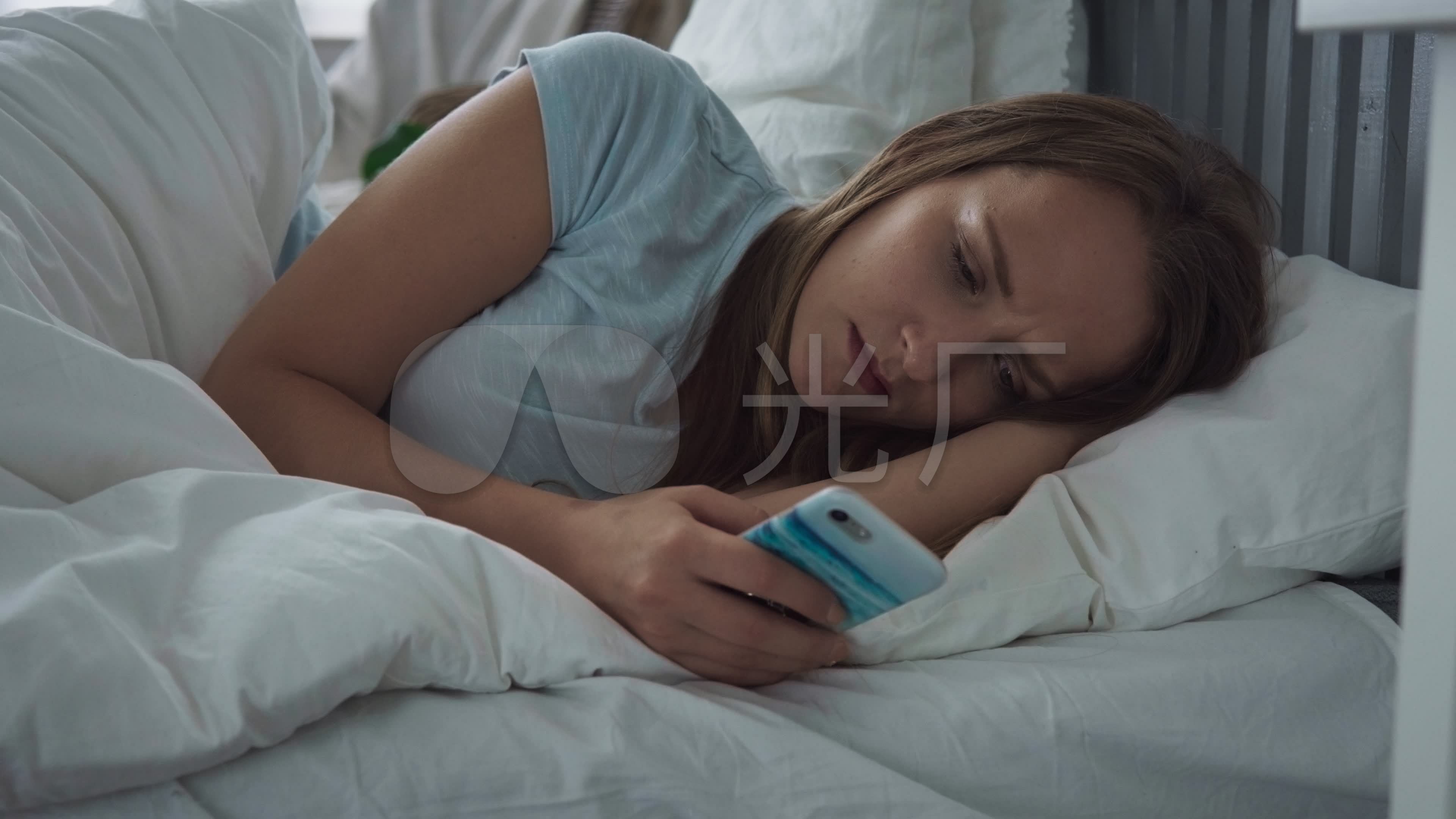 睡在床上玩手机的美女
