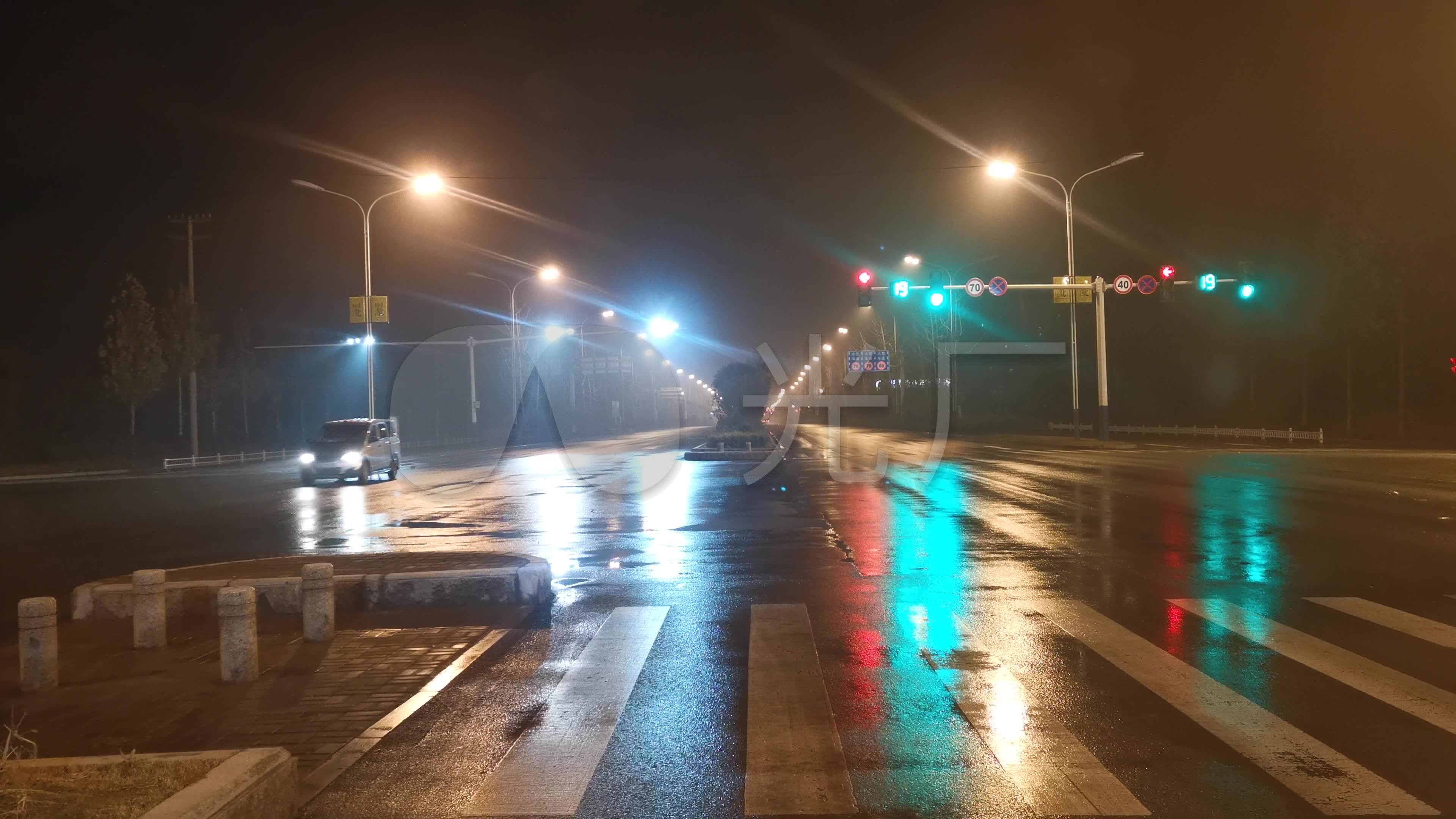 下雨的夜晚在城市道路十字路口等待红绿灯