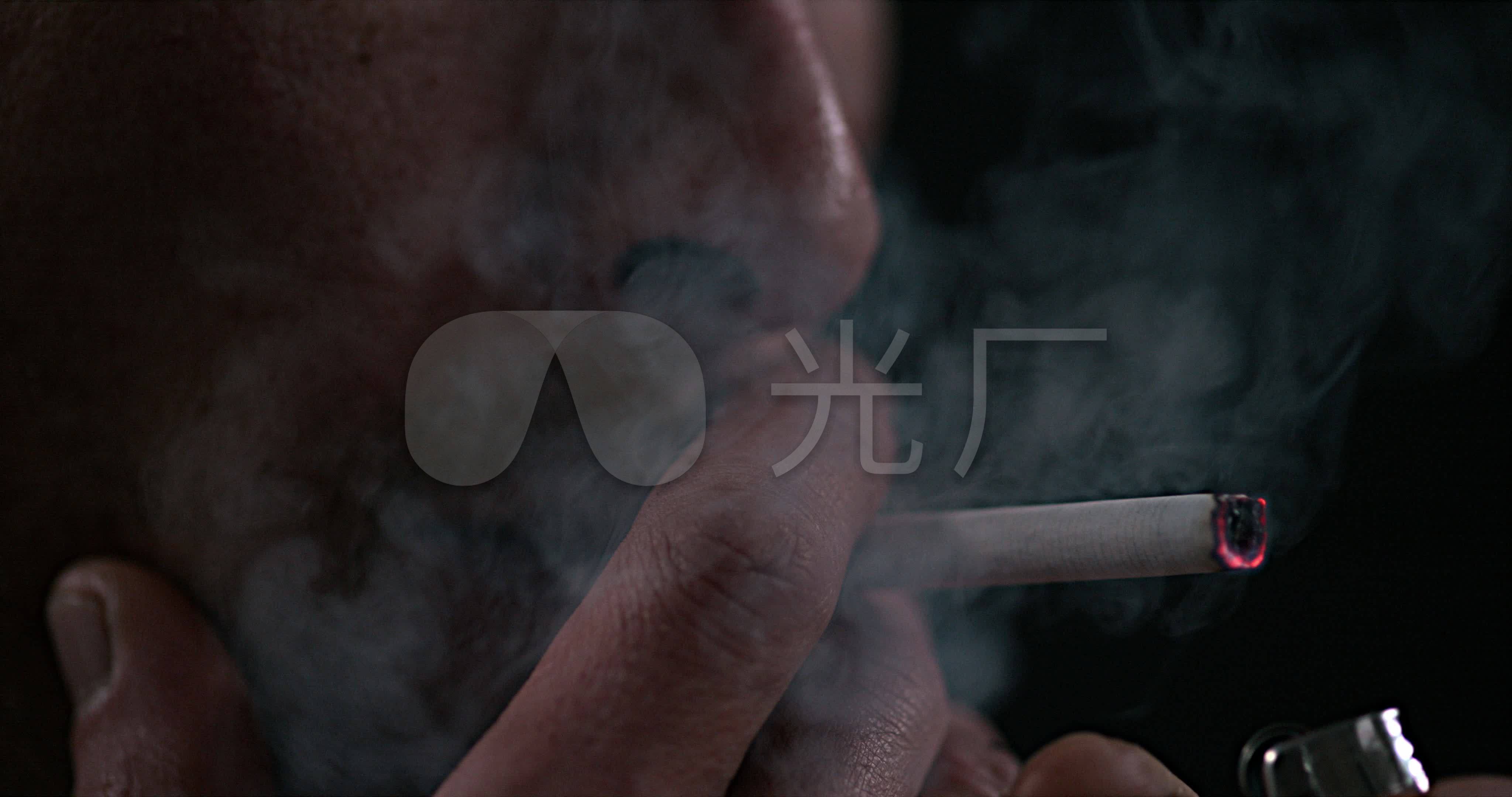 在黑色背景下抽烟的男人