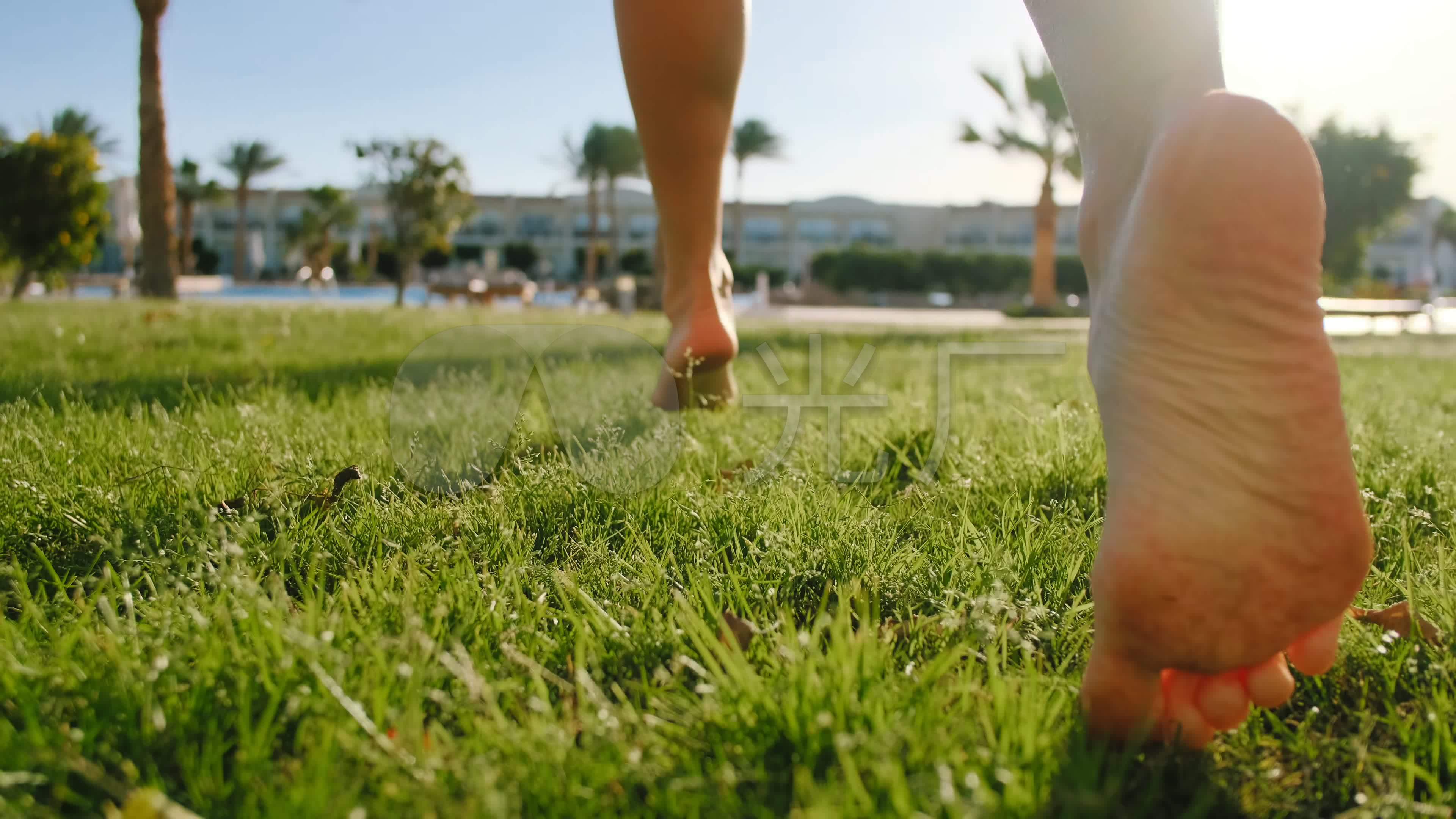 小女孩赤脚在绿草上奔跑的特写镜头.