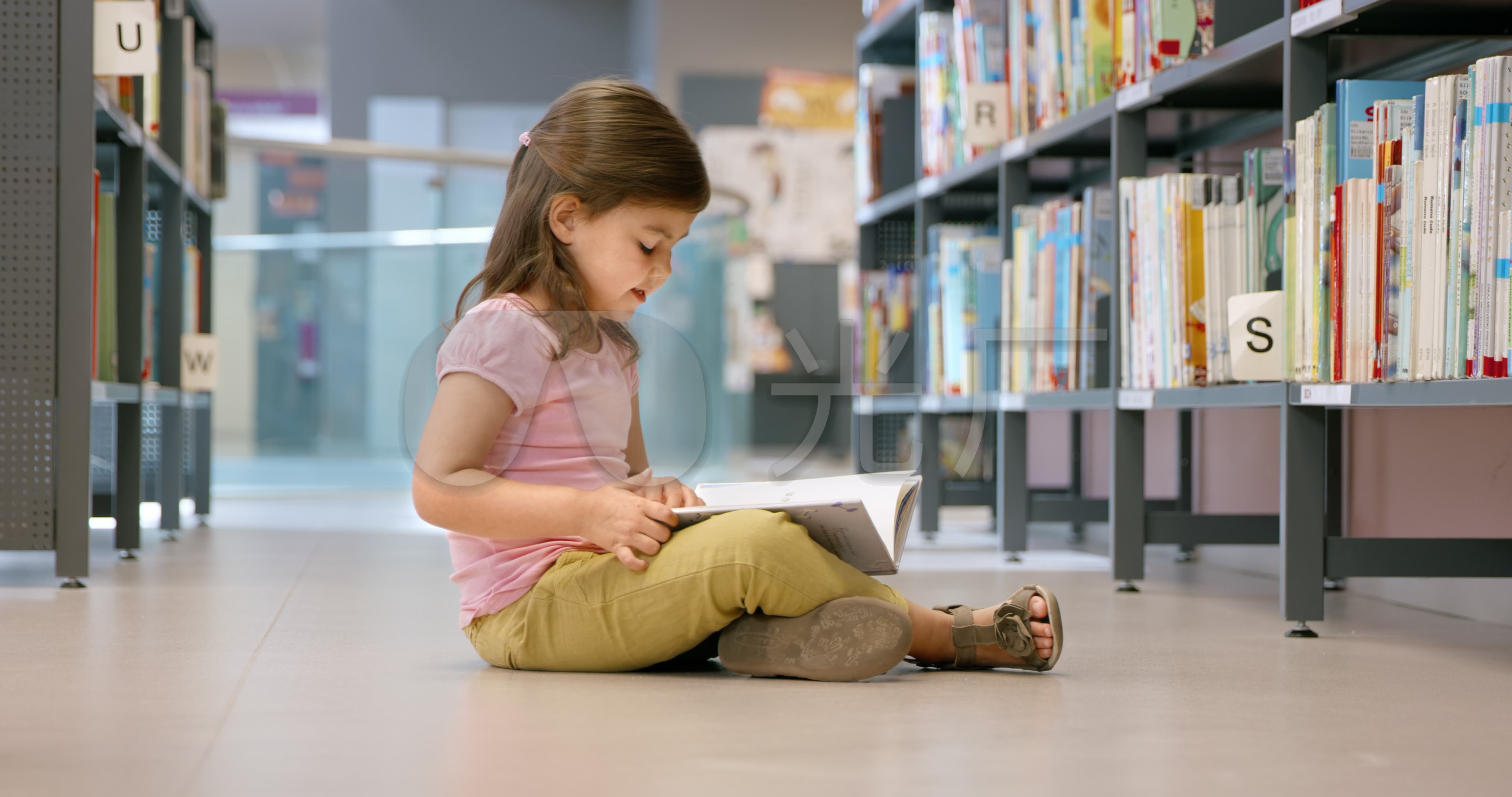 小女孩坐在图书馆的地板上看书_4096x2160_高清视频