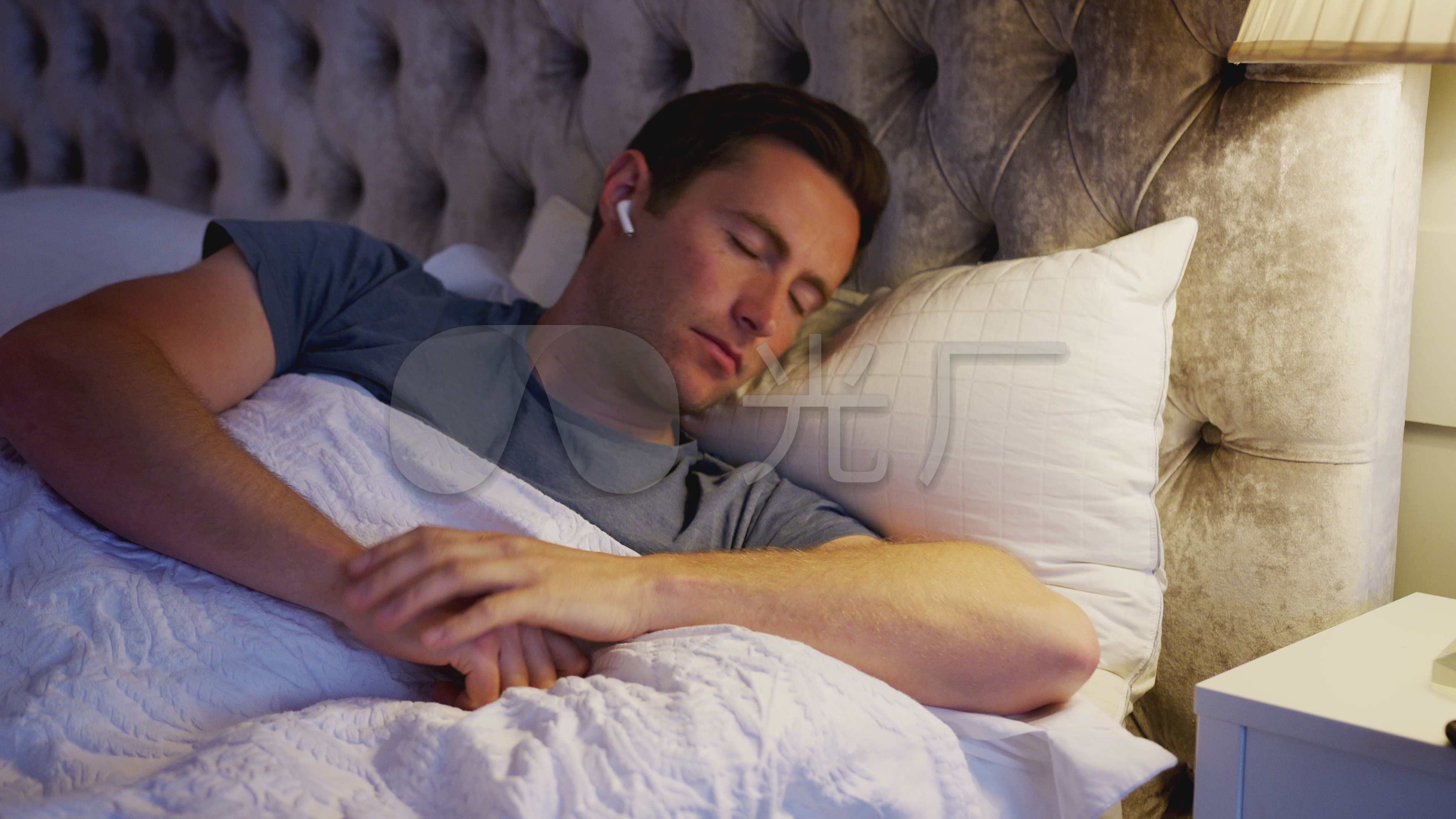 男人在睡觉前把无线耳机戴上