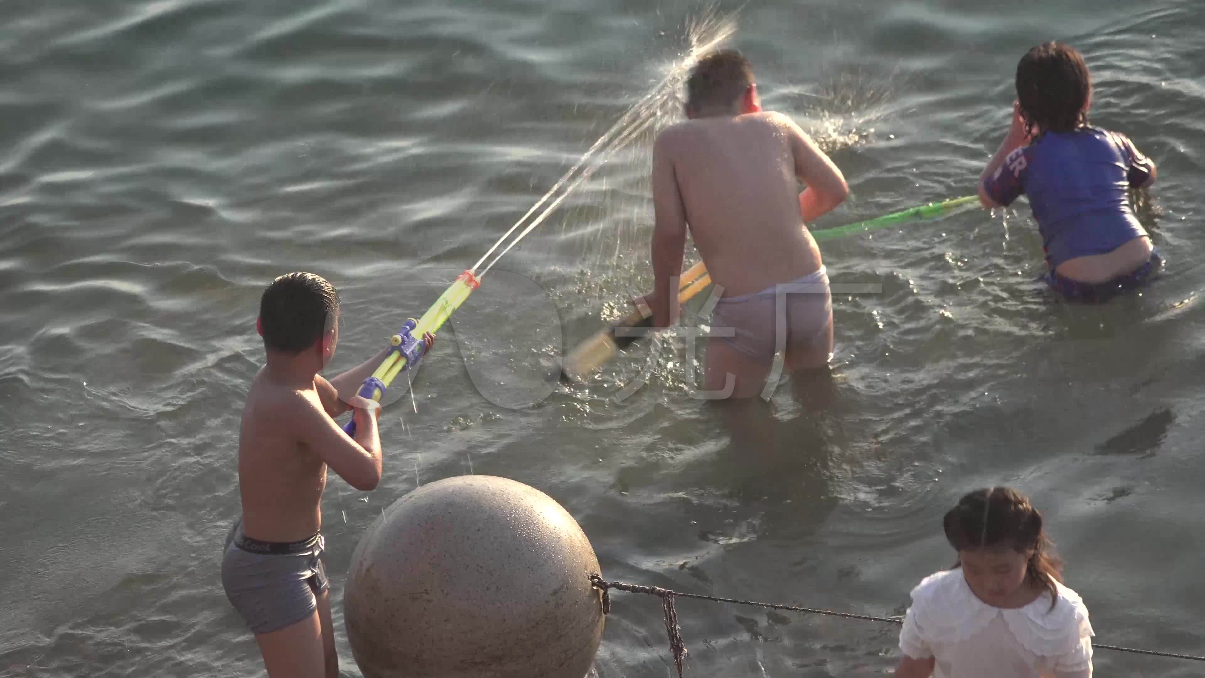 夏日黄昏少年儿童在浅河中戏水