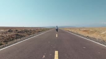 4k新疆高原笔直的公路上行走的摄影师视频素材