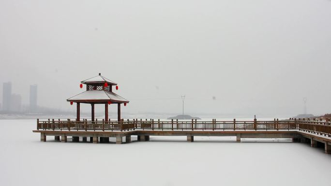 公园景区亭台楼阁和红色柏油路下雪小景