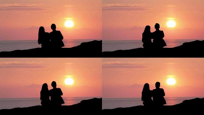 情侣剪影在海边看夕阳