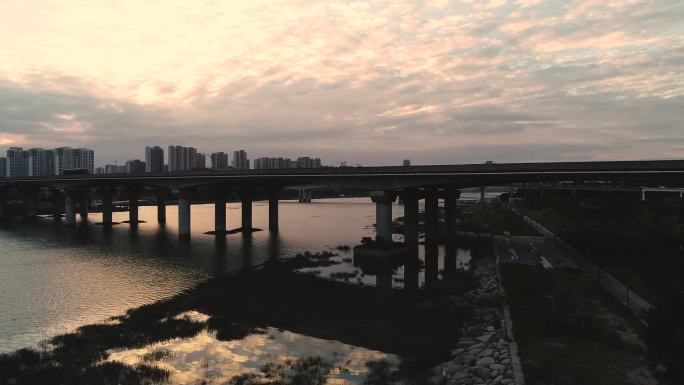 夕阳西下的福建泉州晋江上高速路桥世贸大厦