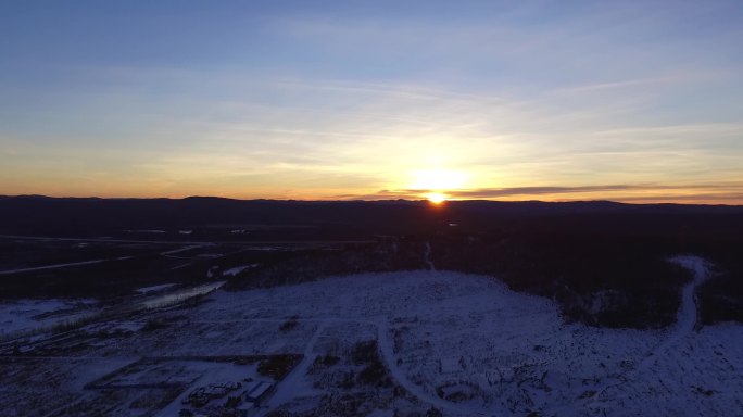 航拍漠河冬季郊外雪地爬升夕阳出镜