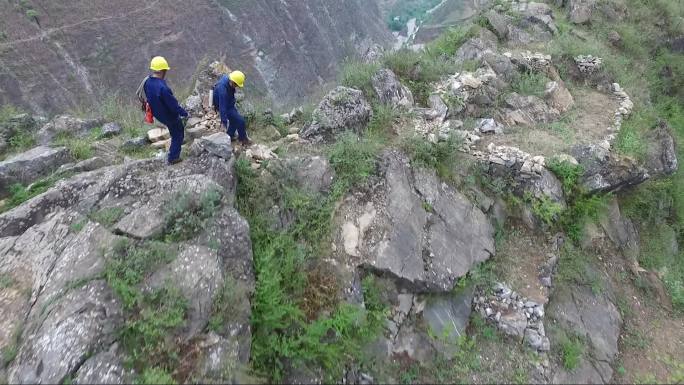 航拍大山里的电力巡线工人