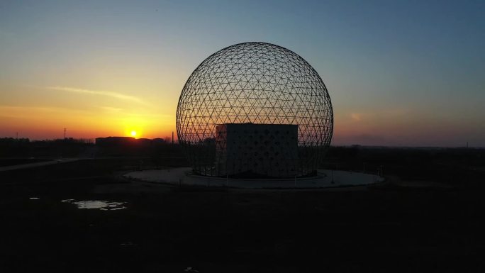 航拍夕阳下的球形钢构建筑