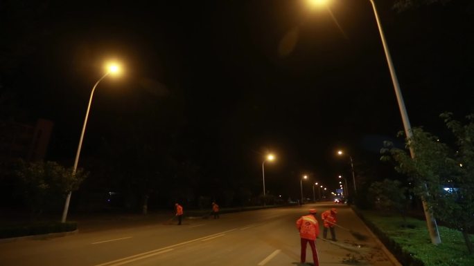 夜幕下的环卫工人打扫马路
