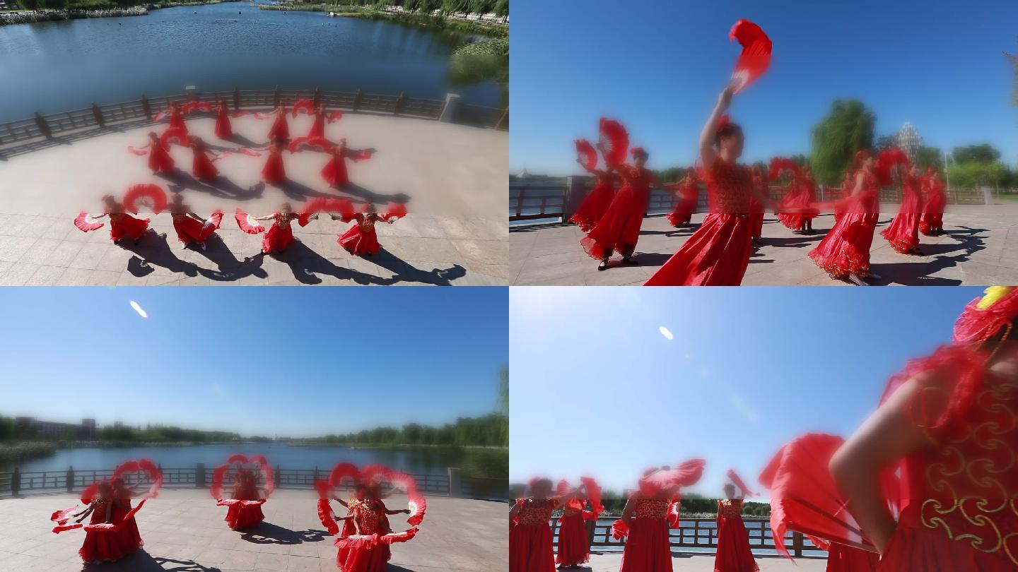 湖边穿着红色喜庆裙子拿着扇子跳舞的大妈