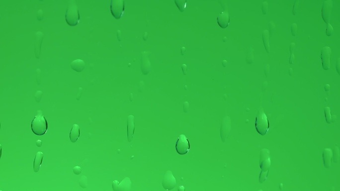 绿色背景前的水滴滑落