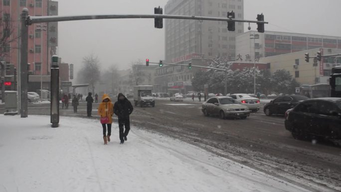 鹅毛大雪中路上车辆行人