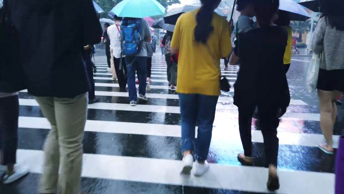 羊城广州大雨，五一假期逛街的市民撑伞而行