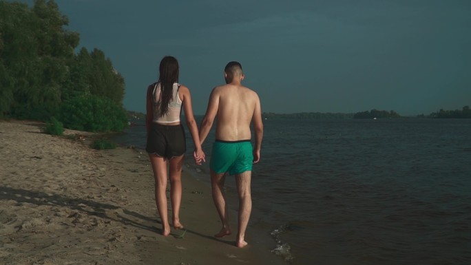 情侣在海边行走背影