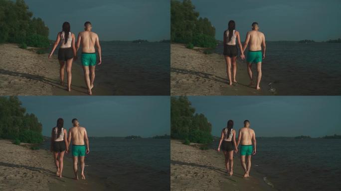 情侣在海边行走背影