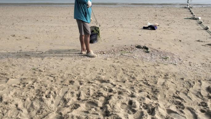早晨环保清洁工人清洁海滩的垃圾