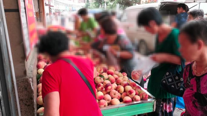 水果摊前挑选降低促销人群买水果桃子