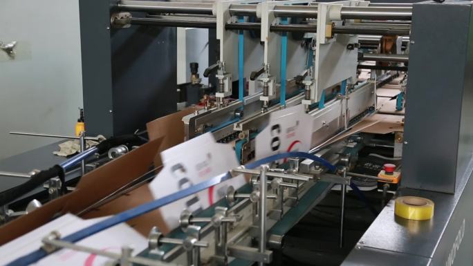 印刷厂自动糊盒机工作实拍视频素材