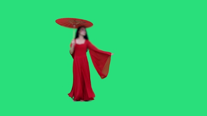 女人穿着红衣拿伞迎风吹