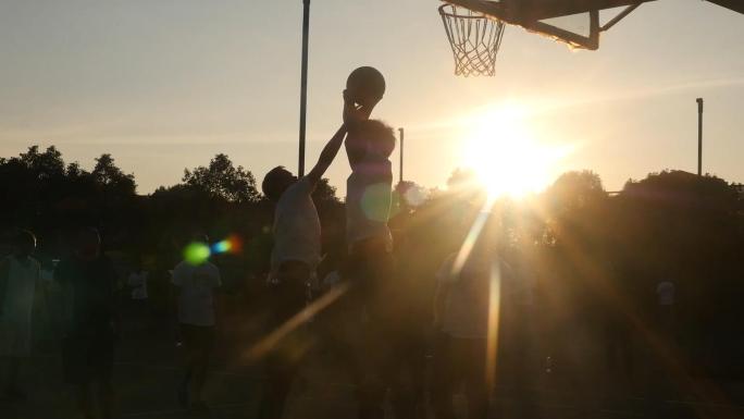 意境唯美的黄昏下一群年轻人打篮球锻炼身体