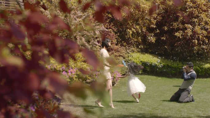 秋景亲子一家三口草坪上游玩吹泡泡拍照