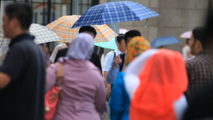 街头下雨打伞的行人