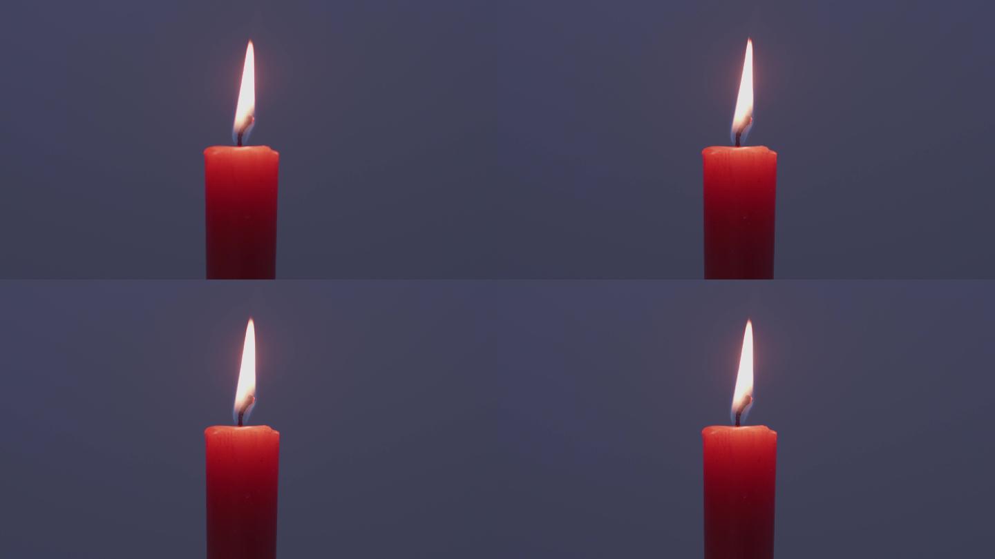 红色的蜡烛火焰在空中舞动点亮了黑暗背景花纹素材