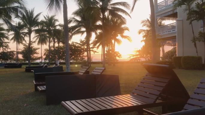 夕阳度假酒店晚霞椰树躺椅海边