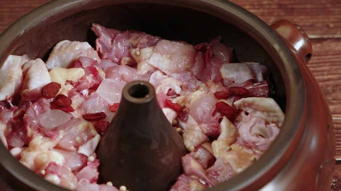 汽锅里切好的鸡肉和落入的红色枸杞上