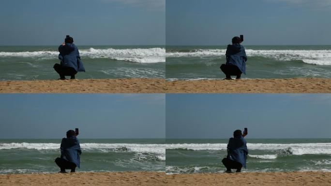 海边人物拿手机拍摄