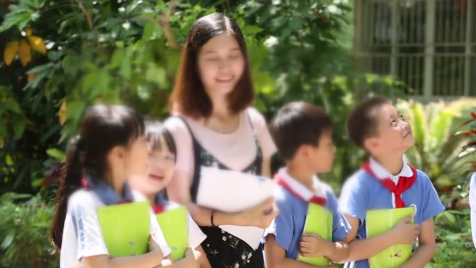 老师和学生参观植物园学生开心浇花