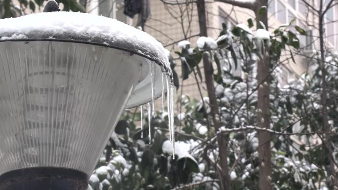 雪花飞舞中路灯上的冰柱