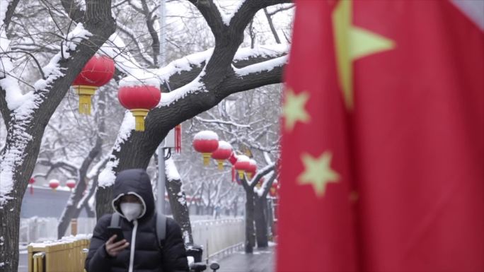 喜庆的北京胡同迎来下大雪，国旗插满胡同口