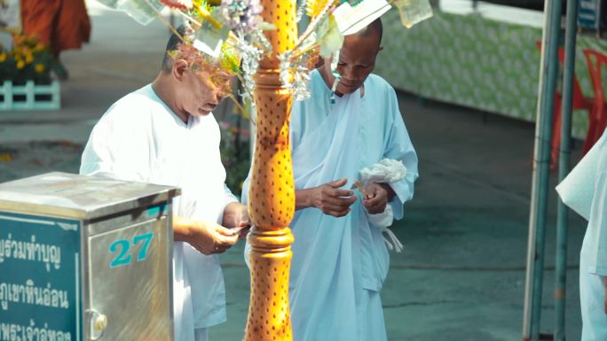 游客在泰国的寺庙里挂心愿金叶
