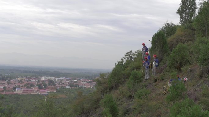 地矿测绘员爬到山顶测绘矿产资源
