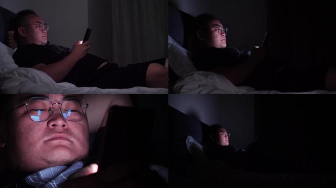 失眠晚上躺在床上玩手机的男人