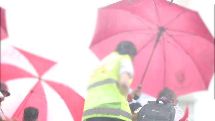 家长义工下雨天帮学生打伞进学校