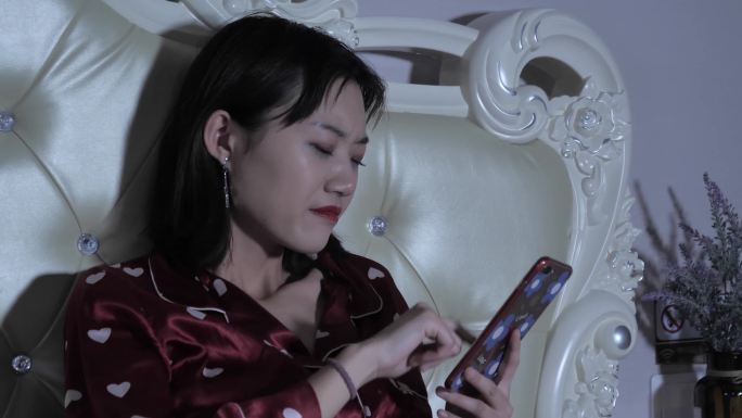 半夜不睡觉躺在床上玩手机的女孩