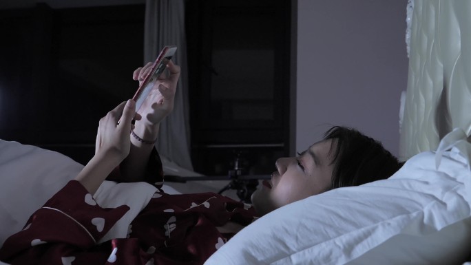 半夜在床上玩手机的女孩