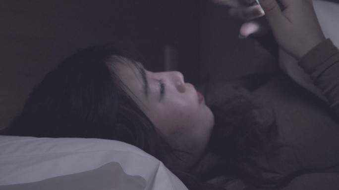 躺在床上玩手机的女孩熬夜玩手机