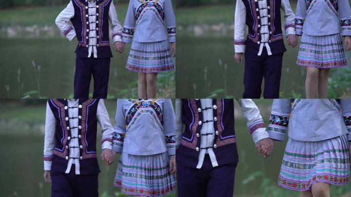 少数民族布依族穿民族服饰水边牵手恋爱