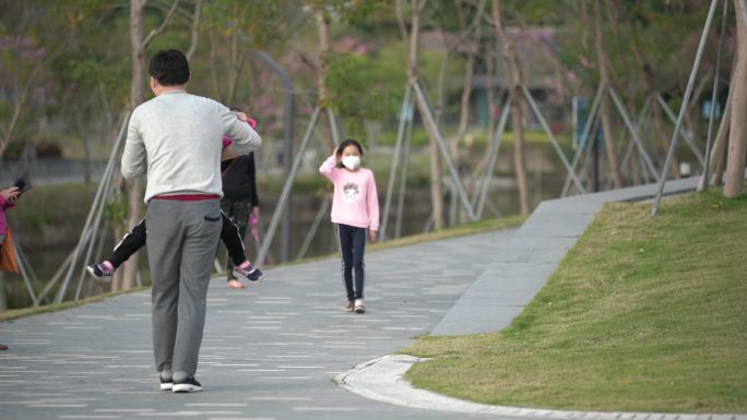 在公园里玩耍的孩子奔向父亲