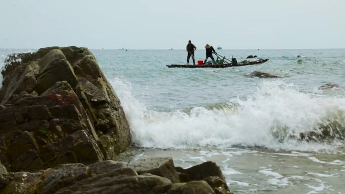 胶州海边石礁渔夫打渔