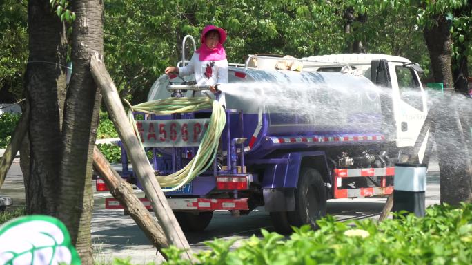 4K实拍烈日下洒水车浇灌花草