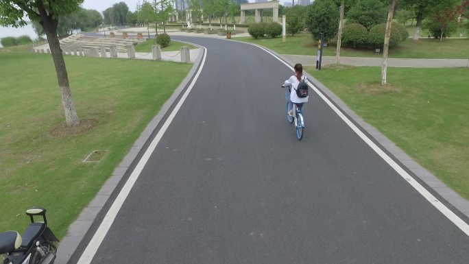 航拍跟随美女骑行共享单车