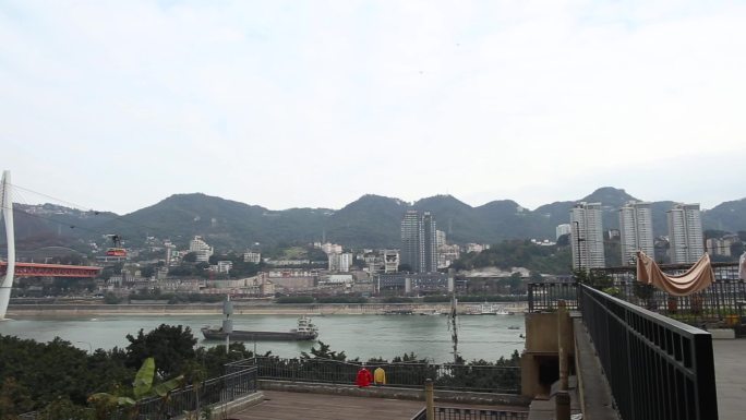 外国人在江边的建筑群看着重庆的桥梁与缆车